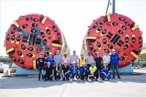 中外員工在盾構(gòu)機(jī)前合影。中國電建供圖