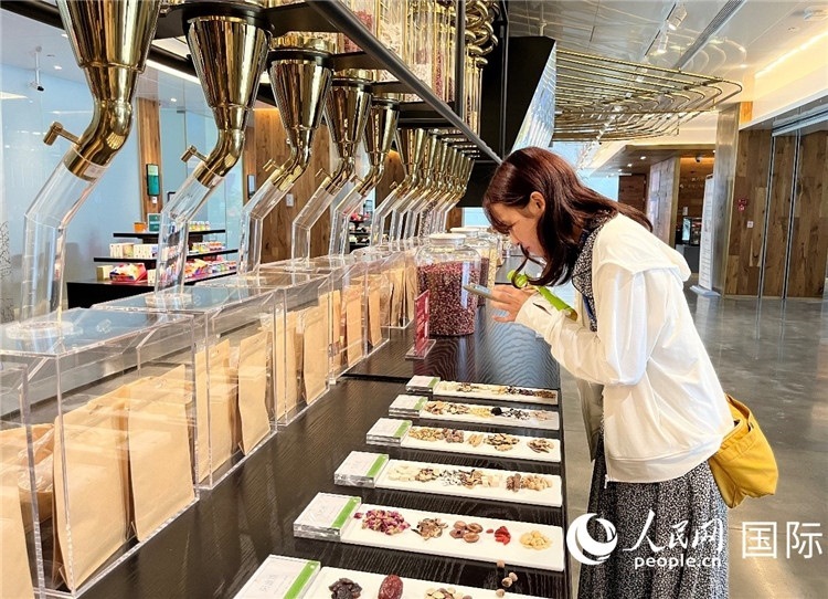 4. 代表團(tuán)團(tuán)員對(duì)新中式茶飲的食材充滿(mǎn)興趣。（人民網(wǎng)記者陳思 攝）