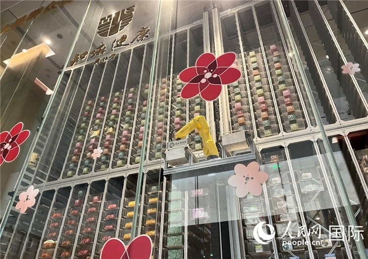 6. 機(jī)械臂正在取貨。（人民網(wǎng)記者陳思 攝）