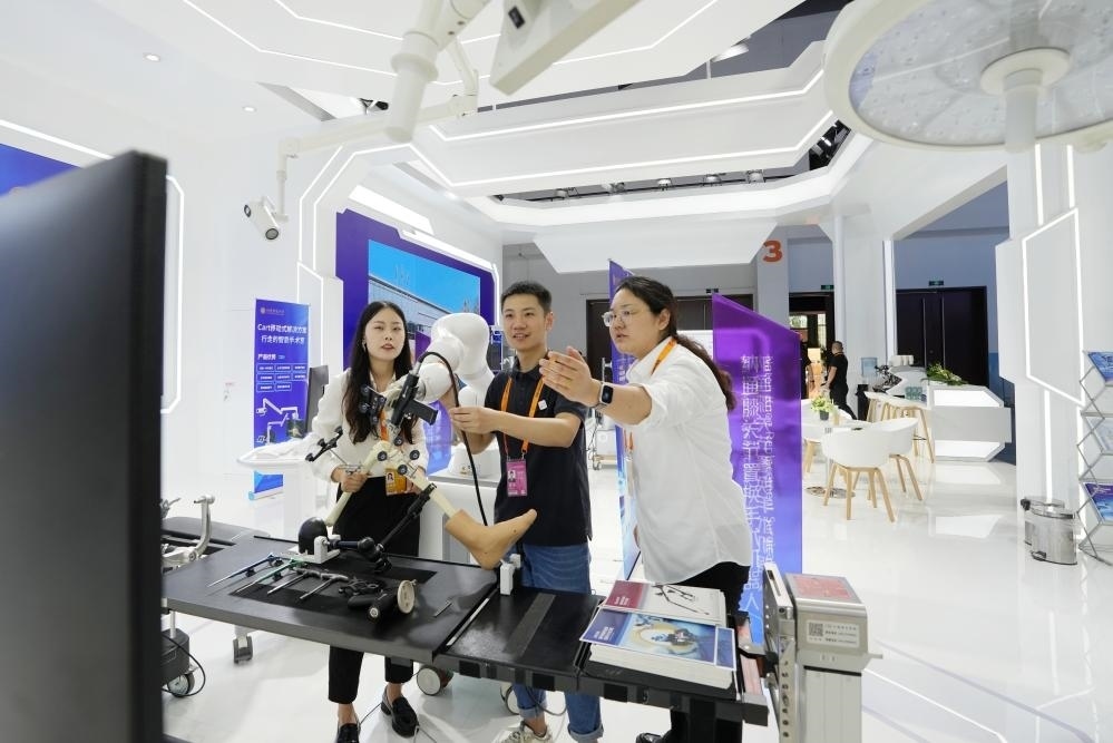 9月11日，一位媒體記者（中）在2024年服貿(mào)會(huì)國(guó)家會(huì)議中心會(huì)場(chǎng)體驗(yàn)北京納通科技集團(tuán)有限公司的膝關(guān)節(jié)置換手術(shù)機(jī)器人。新華社記者鞠煥宗 攝