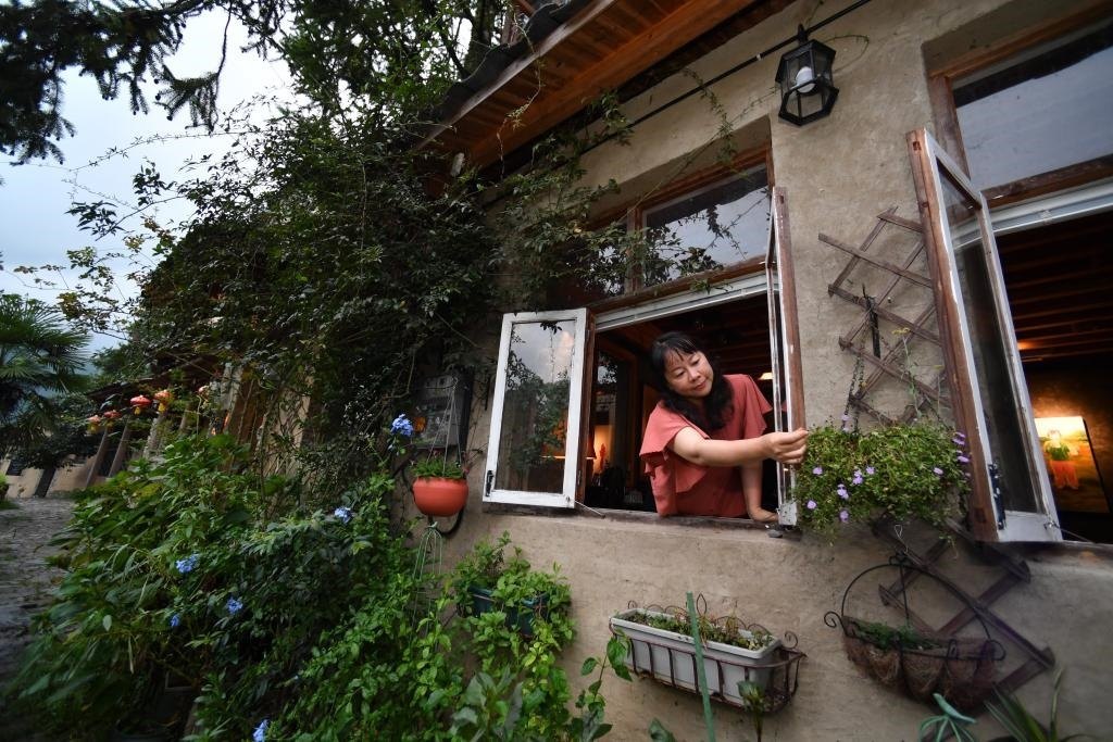 8月29日，在福建省屏南縣熙嶺鄉(xiāng)，龍?zhí)洞濉靶麓迕瘛泵泛暝诖蚶碜约航?jīng)營的民宿外墻裝飾花盆。新華社記者姜克紅 攝