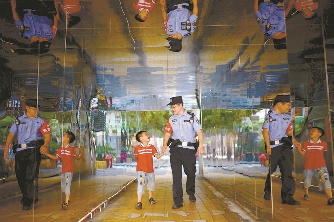 ?7月16日，重慶市公安局江北區(qū)分局一名民警在巡邏途中遇到一個(gè)獨(dú)自玩耍的小男孩，民警將其送回家。王洪平攝