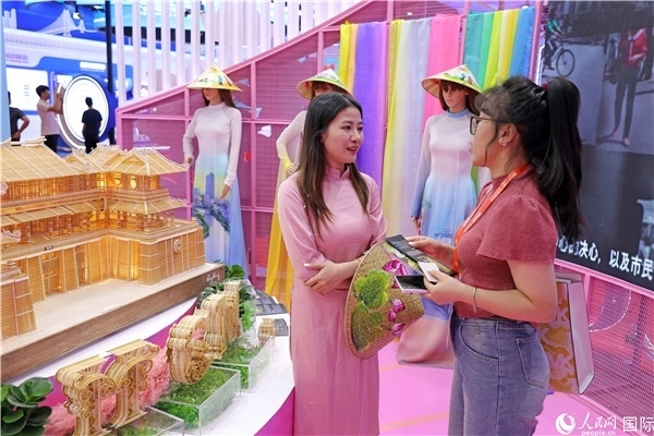 參觀者在東博會(huì)越南展區(qū)同工作人員咨詢交談。人民網(wǎng)記者 趙益普攝