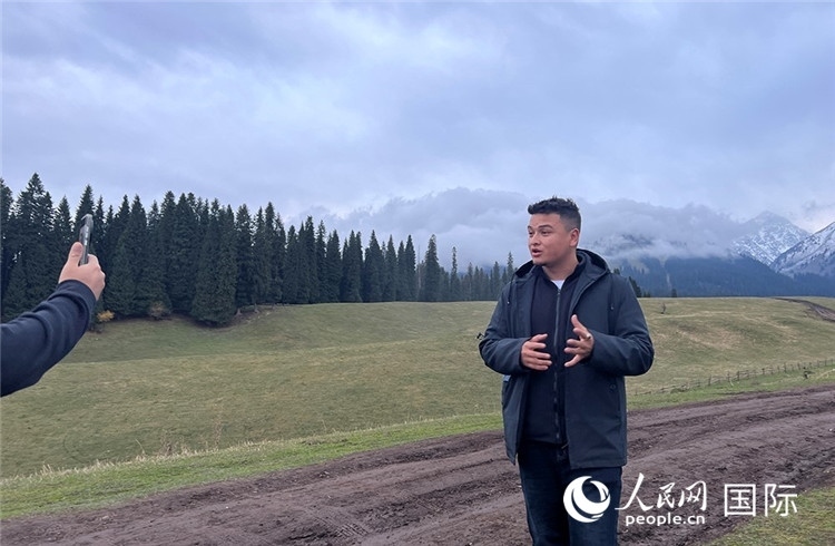 在庫爾德寧，吾買爾江被雪山美景震撼，即興錄制了短視頻作品。人民網(wǎng)記者曾書柔攝