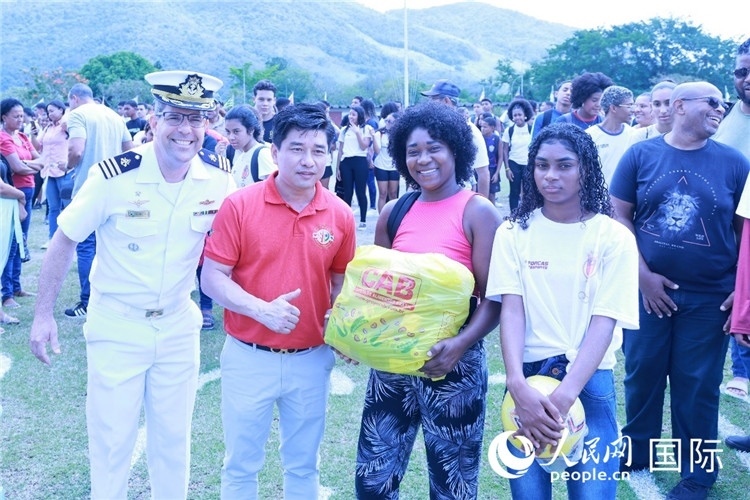 巴西中國浙江商會會長鄭俠茂向巴西貧困社區(qū)兒童及家庭捐贈基礎(chǔ)食品籃子和足球。人民網(wǎng)記者陳海琪 攝