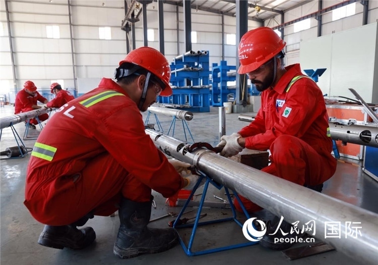 中伊員工共同在檢修鉆井設備。人民網記者管克江攝