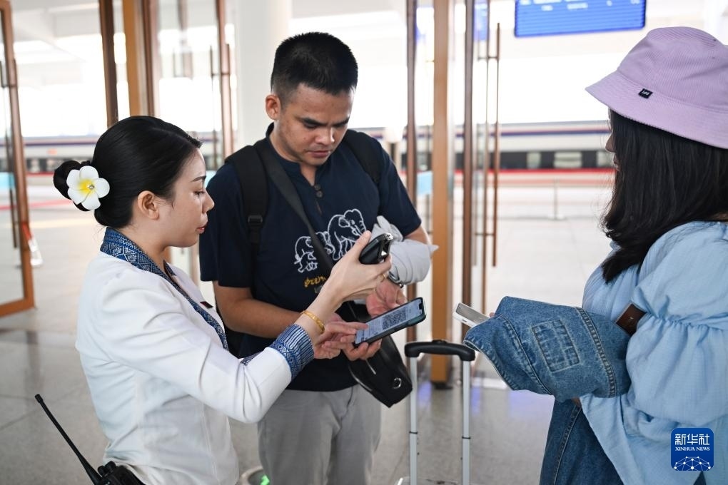 10月12日，在老撾萬象中老鐵路萬象站，工作人員檢驗乘客車票。新華社記者 程一恒 攝