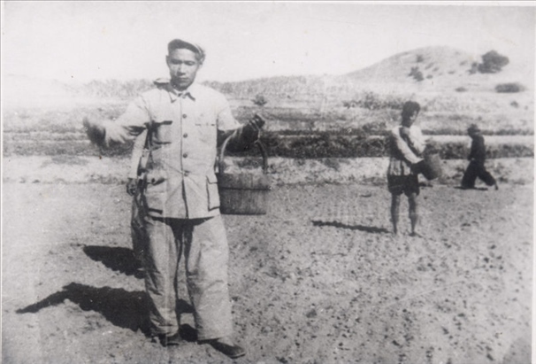 谷文昌（左）在田間與農(nóng)民一起勞動(dòng)（資料照片）。