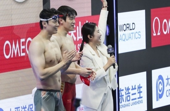  10月18日，汪順（左）和潘展樂在男子100米混合泳決賽后。新華社記者 方喆 攝