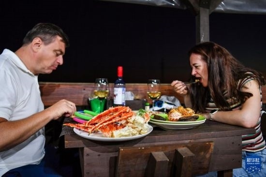 9月2日，食客們在俄羅斯符拉迪沃斯托克的一家餐館品嘗帝王蟹。新華社記者 曹陽 攝