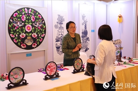 青海非遺文化傳承人向嘉賓介紹展品。人民網(wǎng)實習(xí)生姚欣可攝