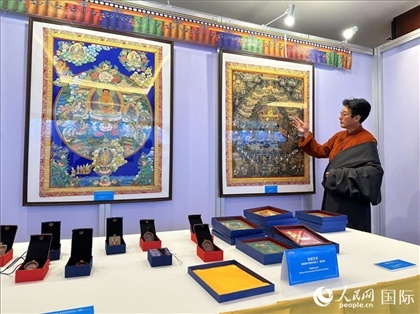 熱貢藝術(shù)國家級代表性傳承人夏吾角向嘉賓介紹作品。人民網(wǎng)記者 簡承淵攝