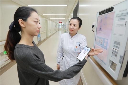 醫(yī)護(hù)人員引導(dǎo)患者在自助機(jī)前辦理自助入院手續(xù)。圖片來(lái)源：山東第一醫(yī)科大學(xué)第二附屬醫(yī)院