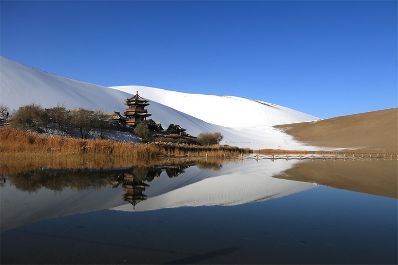鳴沙山月牙泉景區(qū)雪景。敦煌市委宣傳部供圖，張曉亮攝