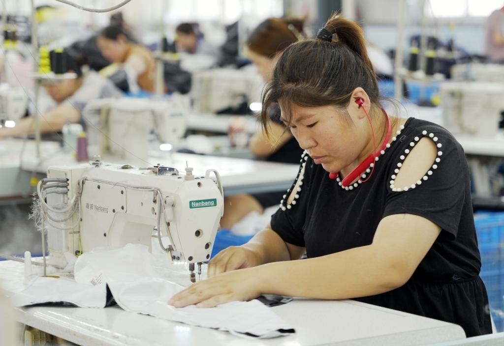 5月20日，村民在李寨村服裝加工廠內(nèi)忙碌。河南省周口市沈丘縣馮營(yíng)鎮(zhèn)李寨村地處豫東平原。近年來(lái)，乘著脫貧攻堅(jiān)與鄉(xiāng)村振興政策的東風(fēng)，李寨村積極探索產(chǎn)業(yè)發(fā)展模式，通過(guò)“龍頭企業(yè)+村集體經(jīng)濟(jì)+農(nóng)戶”的方式，逐漸發(fā)展形成肉牛養(yǎng)殖、設(shè)施農(nóng)業(yè)、服裝加工、康養(yǎng)民宿等產(chǎn)業(yè)，以產(chǎn)業(yè)振興助力鄉(xiāng)村振興。新華社記者 李嘉南 攝