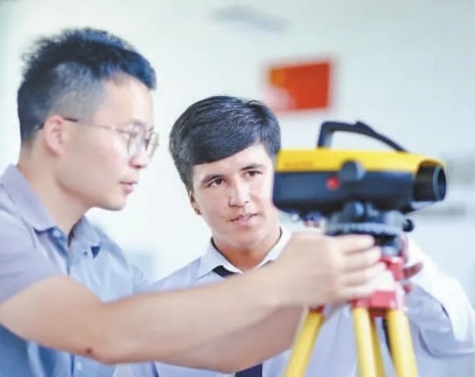 在塔吉克斯坦首都杜尚別的魯班工坊，來自天津城市建設(shè)管理職業(yè)技術(shù)學(xué)院的老師（左）為當(dāng)?shù)貙W(xué)生提供指導(dǎo)。新華社記者 鄭開君 攝