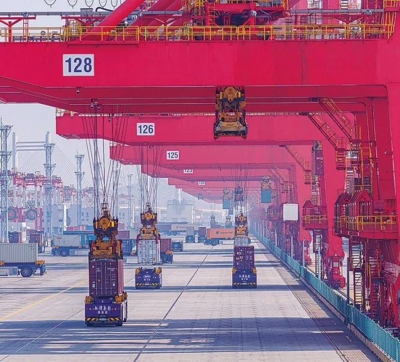 共建“一帶一路”國(guó)家在工作制度對(duì)接、技術(shù)標(biāo)準(zhǔn)協(xié)調(diào)、檢驗(yàn)結(jié)果互認(rèn)等方面強(qiáng)化合作、統(tǒng)一標(biāo)準(zhǔn)，貿(mào)易自由化便利化水平不斷提升。上海洋山港海關(guān)對(duì)接共建國(guó)家進(jìn)出口貨物相關(guān)標(biāo)準(zhǔn)，推動(dòng)通關(guān)一體化方式申報(bào)，提升通關(guān)效率。圖為無人駕駛的全自動(dòng)導(dǎo)引車在洋山港穿梭往來，搬運(yùn)集裝箱。王初 攝