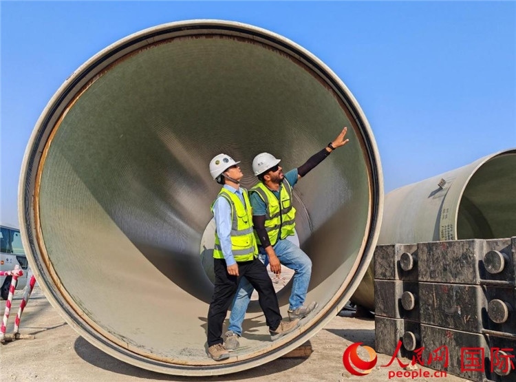 工作人員在察看輸水管情況。人民網(wǎng)記者 管克江攝