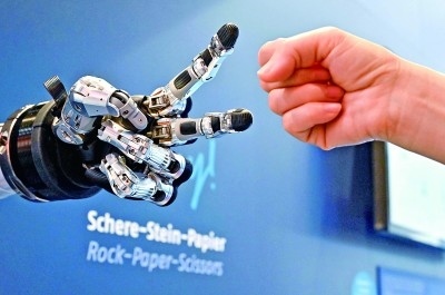 在德國(guó)漢諾威工博會(huì)上，參觀者與一款智能機(jī)器人進(jìn)行“石頭剪子布”游戲。新華社發(fā)