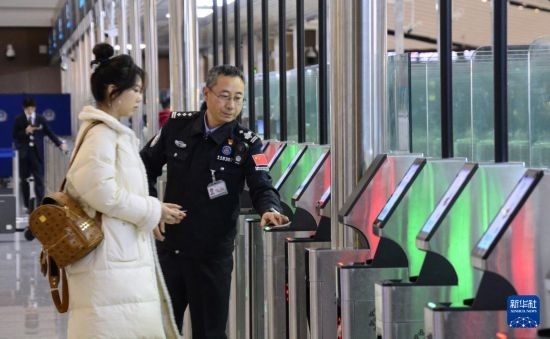 1月2日，大興機場邊檢站警察指導(dǎo)旅客使用自助出境設(shè)備。新華社記者 李欣 攝