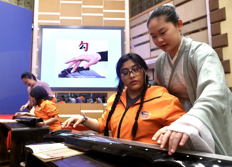 2024年3月20日，美國(guó)華盛頓州中學(xué)生代表團(tuán)北京大學(xué)交流活動(dòng)在北京大學(xué)英杰交流中心舉行。圖為來(lái)自華盛頓州的中學(xué)生體驗(yàn)古琴。