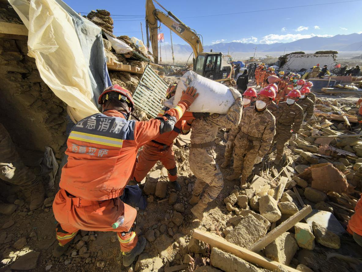 1月11日，定日縣長所鄉(xiāng)古榮村，應(yīng)急消防等救援人員排隊(duì)接力搶運(yùn)掩埋在倒塌房屋下的群眾財(cái)物。人民日?qǐng)?bào)記者楊翹楚攝