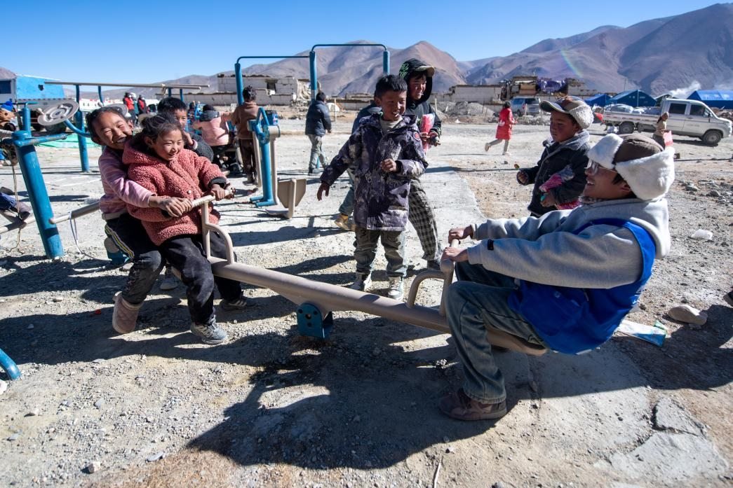1月11日，在定日縣措果鄉(xiāng)塘仁村安置點(diǎn)，西藏星光社會(huì)工作服務(wù)中心志愿者和孩子們一起玩耍，進(jìn)行災(zāi)后心理疏導(dǎo)。人民網(wǎng)記者 翁奇羽攝