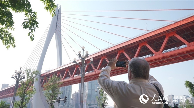 軻寶華“打卡”重慶東水門長江大橋。人民網(wǎng)記者 蘇纓翔攝