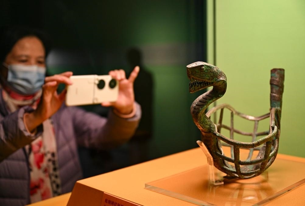 1月14日，觀眾在上海博物館蛇年迎春展拍攝展品蛇綱網(wǎng)狀銅器。新華社發(fā)（陳浩明攝）
