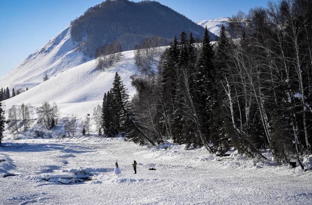 2024年2月5日，兩名游客在新疆阿勒泰地區(qū)布爾津縣禾木村拍照。新華社記者 馬鍇 攝