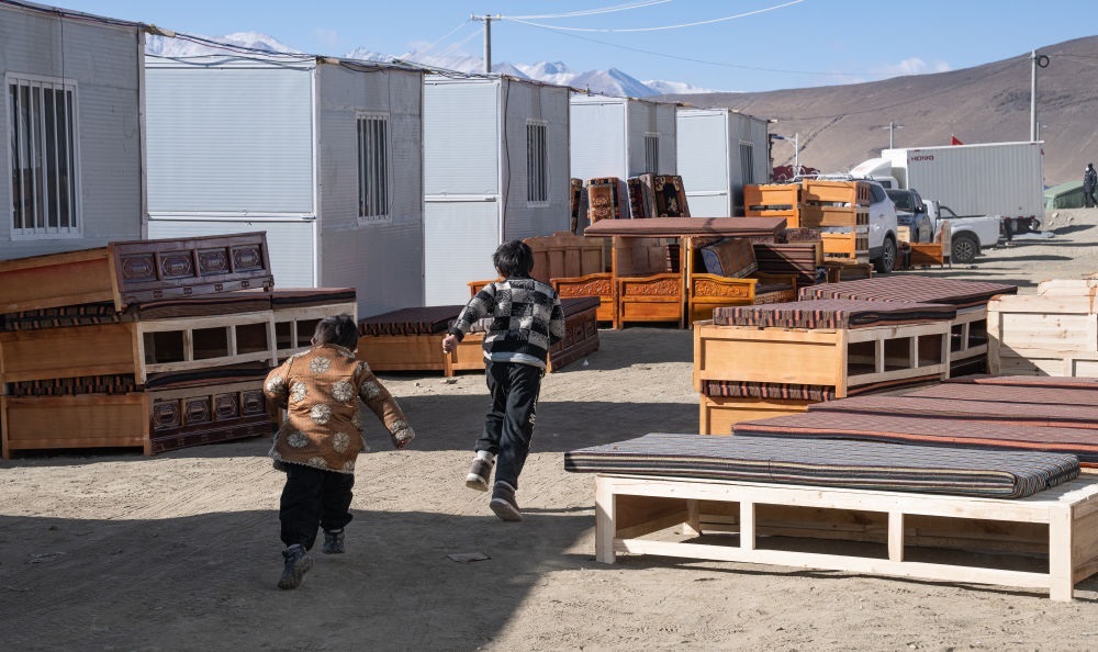 2025年1月13日，在定日縣嘎旦村，兩個孩子在剛運來的兩排藏床間奔跑。新華社記者丁增尼達 攝