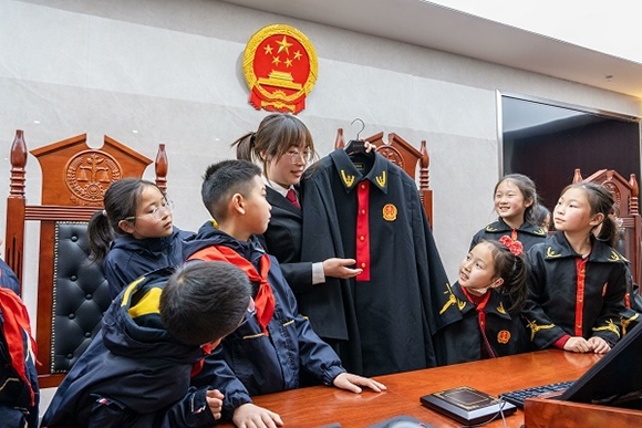 圖②：干警向同學(xué)們介紹法袍。