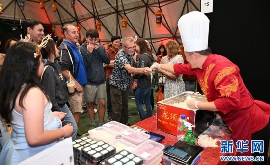 圖為游客在燈節(jié)現(xiàn)場(chǎng)購(gòu)買小吃。（圖片由奧克蘭中國(guó)文化中心提供）