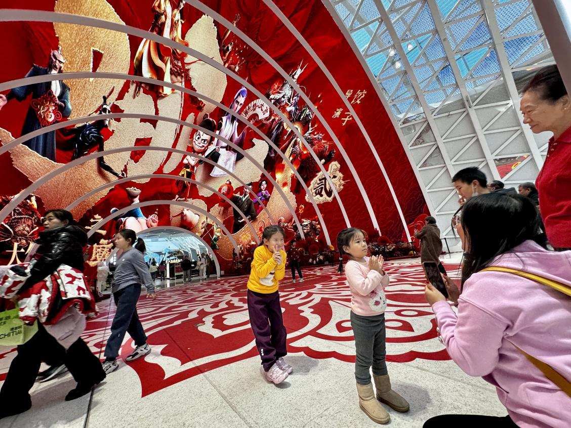 乙巳蛇年春節(jié)期間，影迷在《哪吒之魔童鬧海》巨幅海報前拍照打卡。