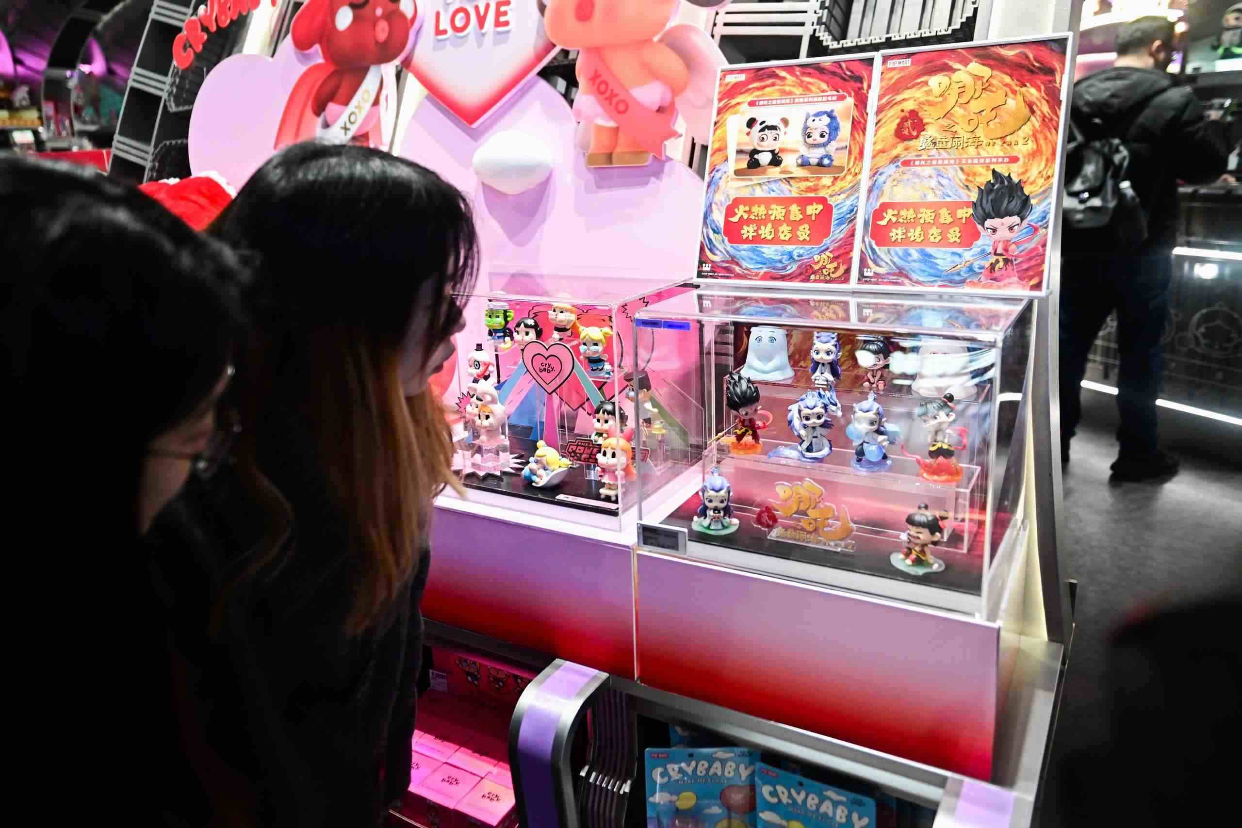 △2025年2月22日，上海，市民在圍觀《哪吒之魔童鬧?！废嚓P(guān)手辦盲盒。