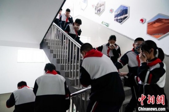  圖為學(xué)生們進(jìn)行應(yīng)急疏散演練。中新社記者 趙宇航 攝