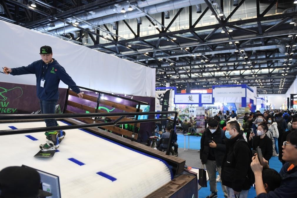 2023年2月11日，參觀者在展會上了解一款模擬滑雪設(shè)備。當(dāng)日，2023亞洲運動用品與時尚展在國家會議中心拉開帷幕。新華社記者 張晨霖 攝