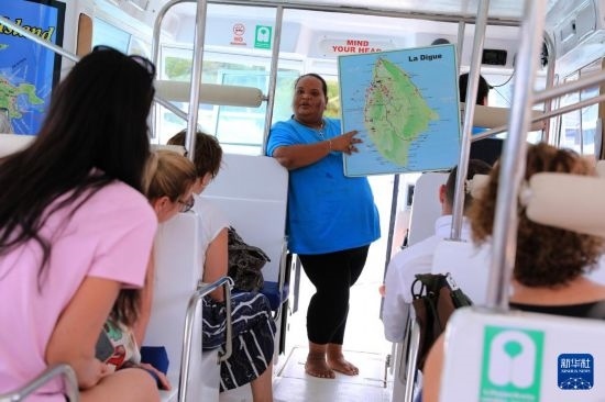 3月15日，一名導游在游艇上為游客介紹塞舌爾拉迪格島。新華社記者 董江輝 攝