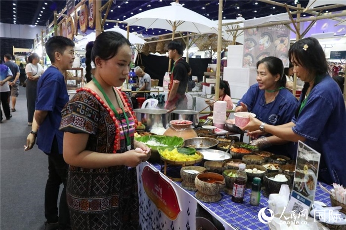 游客在攤位前購(gòu)買(mǎi)特色美食。朱瀟逸攝