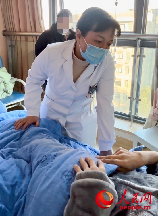 鄧茜查房時(shí)詢問(wèn)患者情況。人民網(wǎng)記者 金慧慧攝