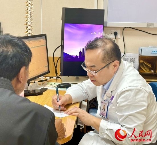 路桂軍接診時(shí)為患者寫(xiě)下用藥提示。人民網(wǎng)記者 金慧慧攝