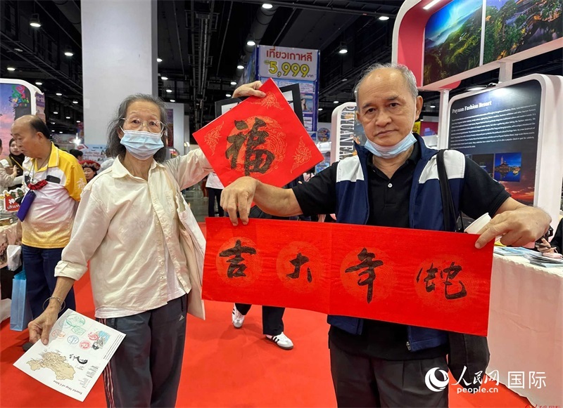 2025蛇年春節(jié)，泰國市民展示他們領(lǐng)到的華人手寫春聯(lián)。人民網(wǎng)記者 簡承淵攝