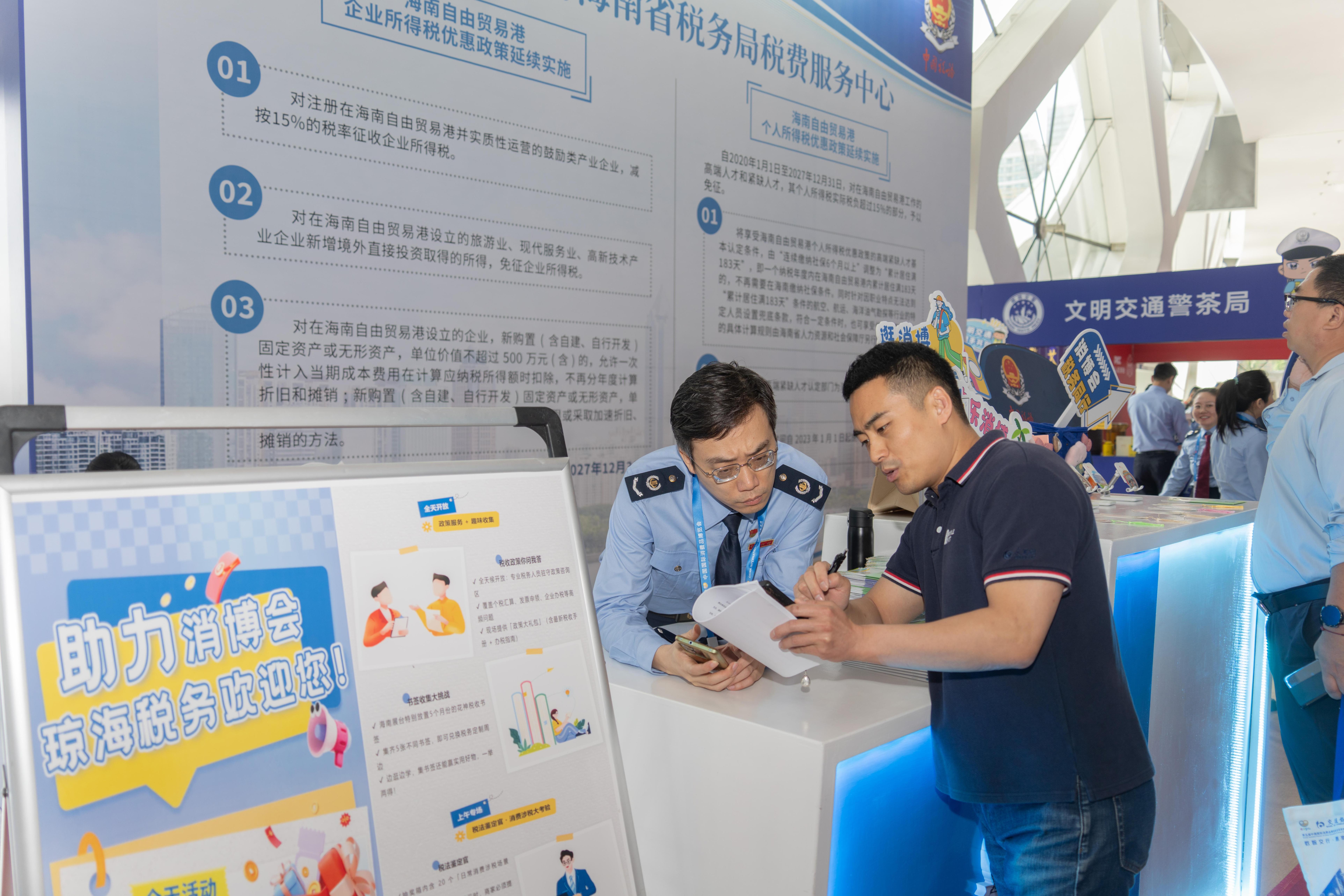 稅務(wù)服務(wù)臺工作人員向記者介紹服務(wù)參展外商的具體舉措。人民網(wǎng)記者 許崢攝