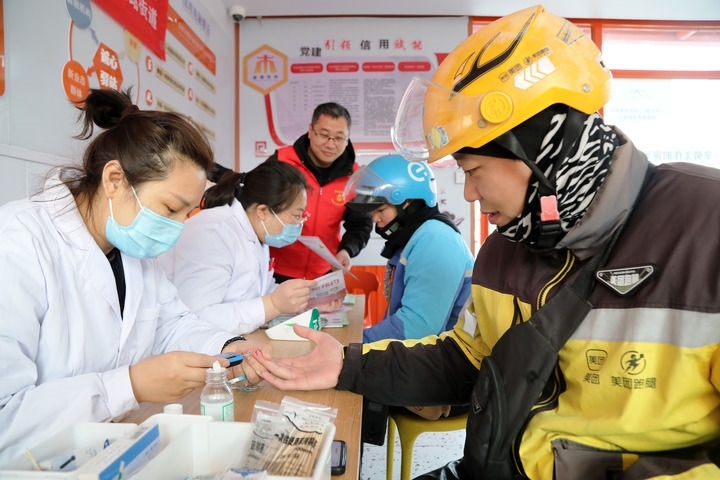 2025年3月5日，志愿者在山東省棗莊市市中區(qū)一工會驛站為外賣員免費測量血糖。新華社發(fā)（王海楠攝）