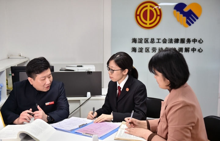 2025年3月6日，在北京市海淀區(qū)總工會勞動爭議調(diào)解中心，海淀區(qū)人民法院法官王琰（中）與該中心工作人員就糾紛化解情況進行溝通。新華社記者 趙婷婷 攝