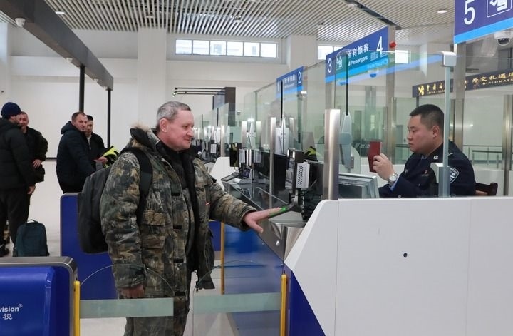 2024年12月10日，在黑河公路口岸旅檢大廳，黑河出入境邊防檢查站民警為首班次客車入境旅客辦理邊檢通關(guān)手續(xù)。當(dāng)日，中國(guó)黑河公路口岸—俄羅斯卡尼庫(kù)爾干公路口岸旅客運(yùn)輸正式開(kāi)通。新華社發(fā)（劉松攝）