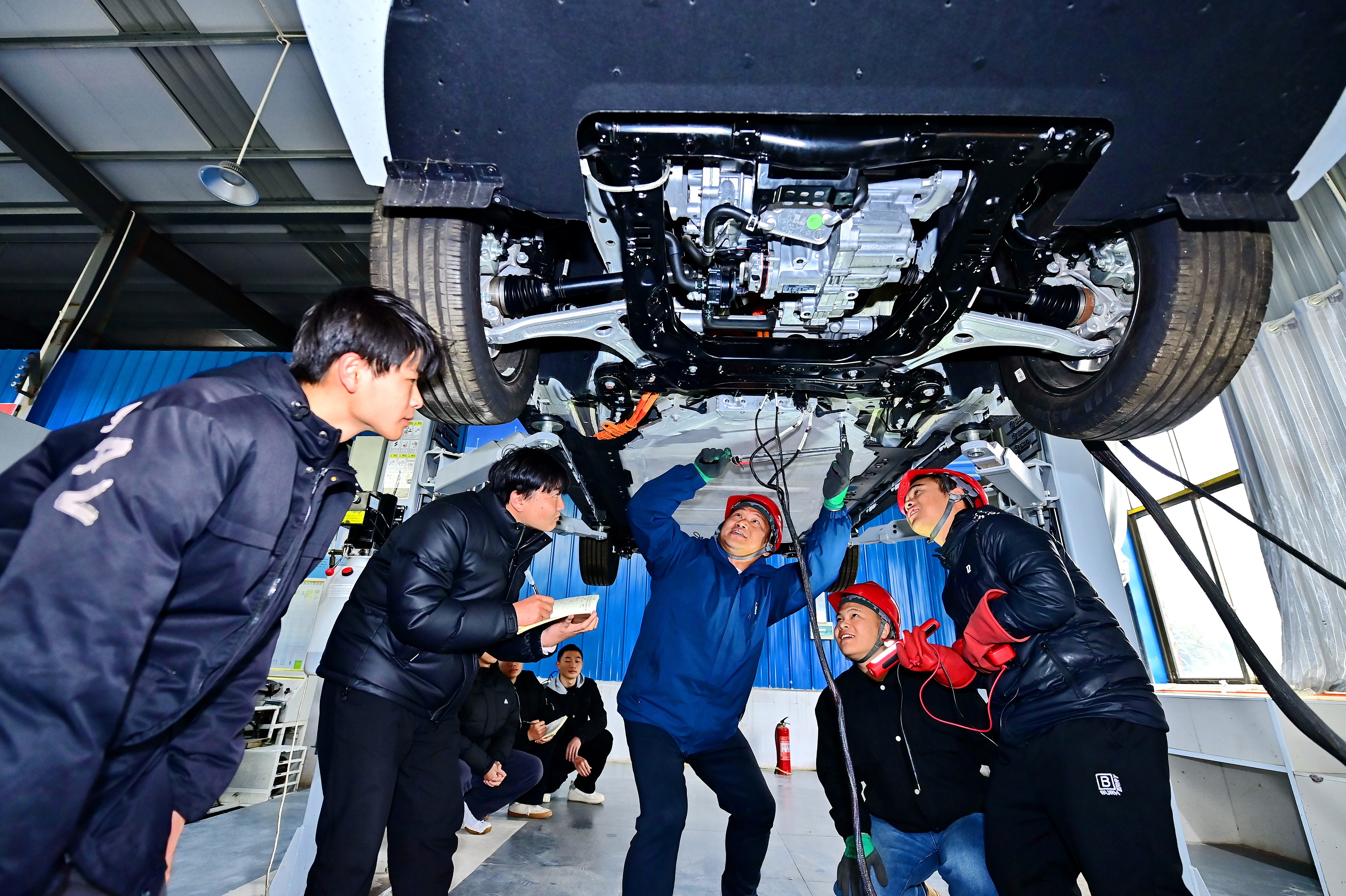 2025年2月，江西省宜春市，豐城市的一所技工學(xué)校實(shí)訓(xùn)基地內(nèi)，新能源汽車運(yùn)維專業(yè)學(xué)生在老師的指導(dǎo)下學(xué)習(xí)新能源汽車電池包檢修技術(shù)。