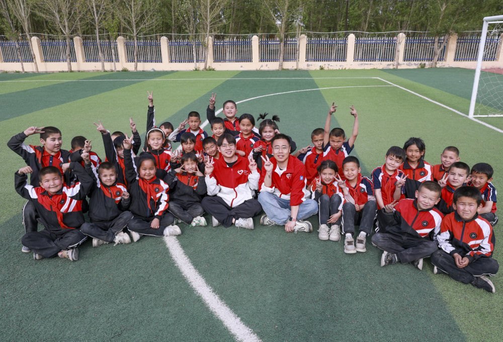 4月23日，在新疆克州阿圖什市哈拉峻鄉(xiāng)謝依特小學(xué)，支教教師王俊文（中左）、李軻凡（中右）和學(xué)生在一起。