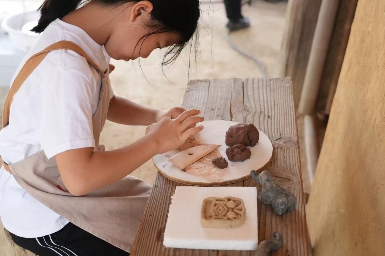 游客制作良渚特色陶藝品。良渚博物院供圖