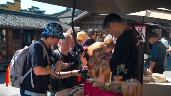 “五一”期間，游客正在烏鎮(zhèn)“水鄉(xiāng)碼頭”挑選購買文創(chuàng)產(chǎn)品。受訪者供圖